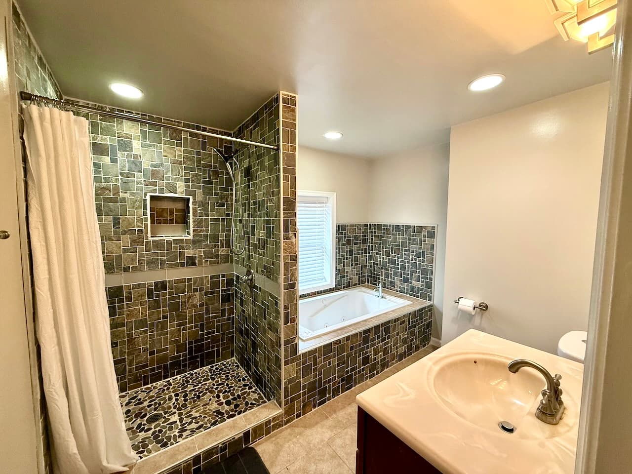 Bathroom with stone tile walk-in shower and soaking tub